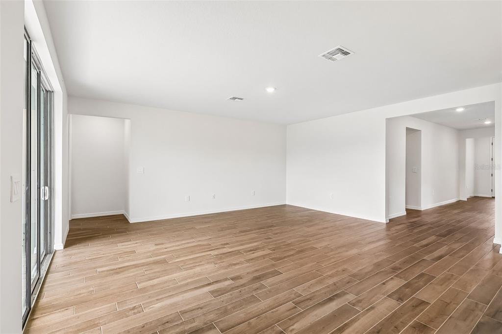 3335 Orchard Loop Bartow, FL 33830 - Photo 8 of 47 a view of an empty room with wooden floor and a window