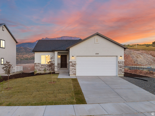 1563 South Deerbrook Road, Unit 267CHM Santaquin, UT 84655 - Photo 2 of 13 Contemporary ranch-style home featuring a two-car garage, stone veneer accents, and a dark wood-finish entry door