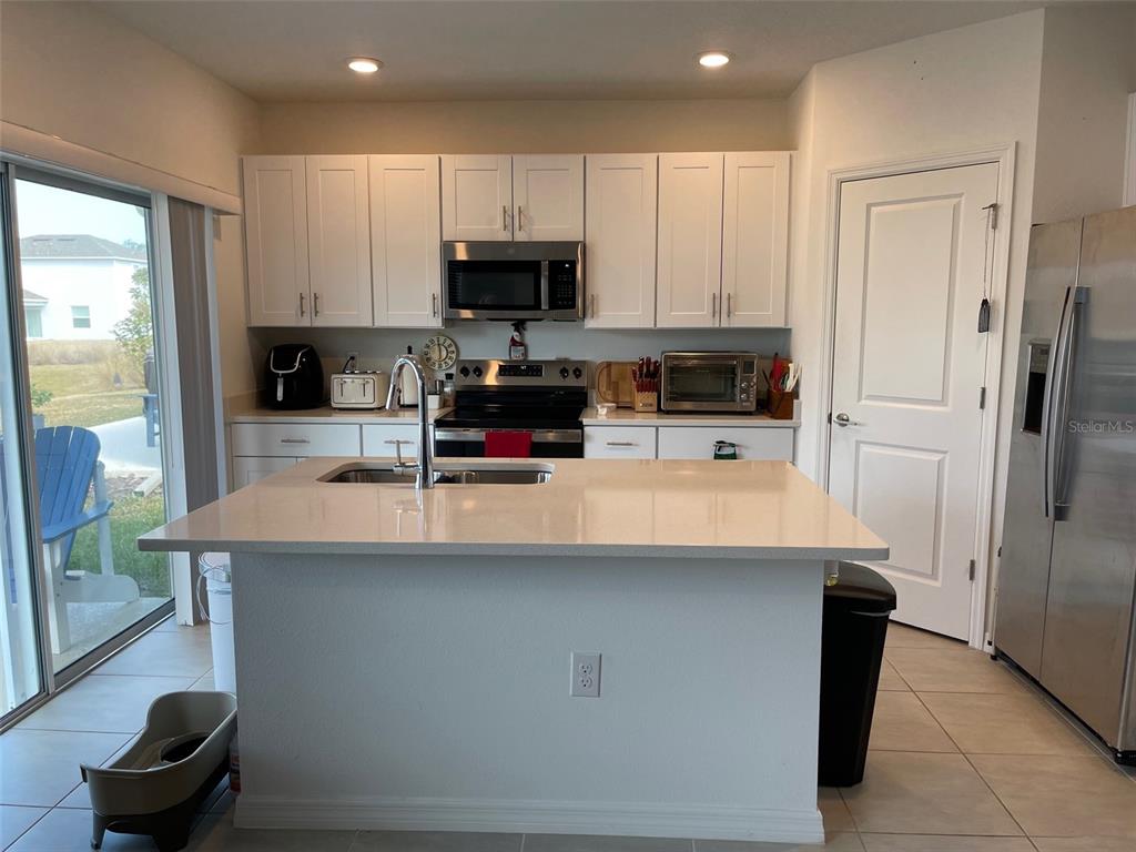 365 River Front Way Edgewater, FL 32141 - Photo 11 of 34 a kitchen with stainless steel appliances a refrigerator sink and microwave