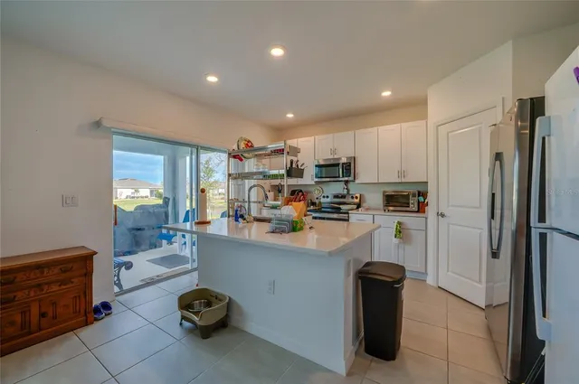 a kitchen with refrigerator and cabinets