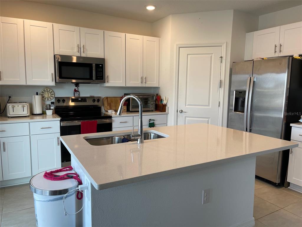 365 River Front Way Edgewater, FL 32141 - Photo 13 of 34 a kitchen with kitchen island a sink dishwasher a stove and a refrigerator