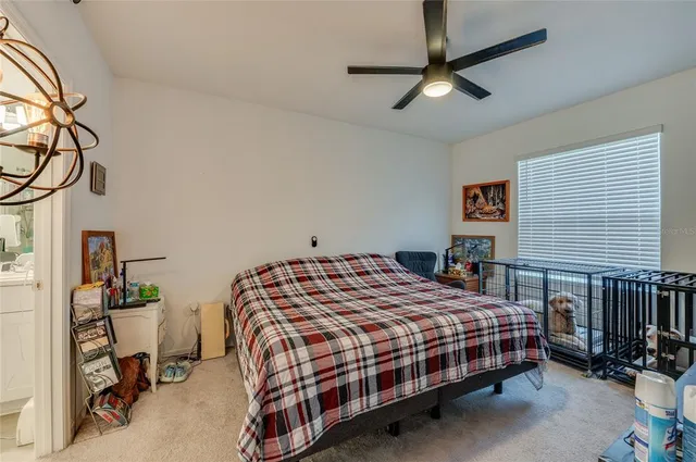 a bedroom with a bed a dresser and potted plant