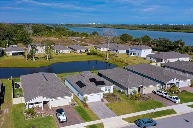 an aerial view of residential houses with outdoor space and ocean view