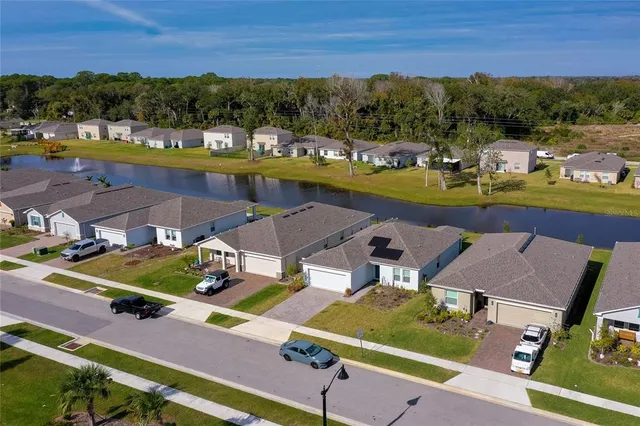 an aerial view of a house with a garden and lake view