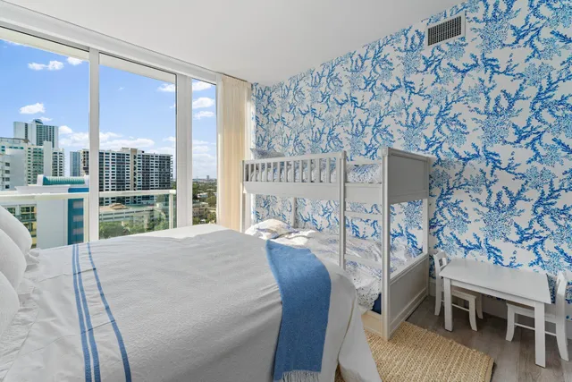 a bedroom with a bed and a flat tv screen on dresser