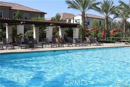 a front view of a building with small garden and palm trees