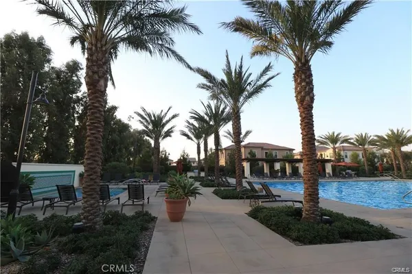 a palm tree sitting in front of a house with trees