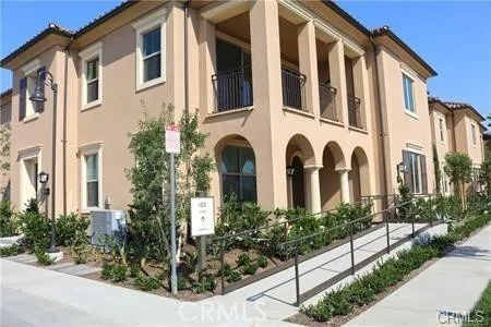a front view of a multi story residential apartment building with yard and bench