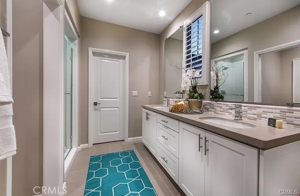 a bathroom with a double vanity sink and a mirror