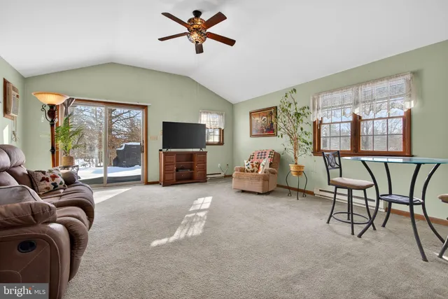 a living room with furniture a flat screen tv and a large window