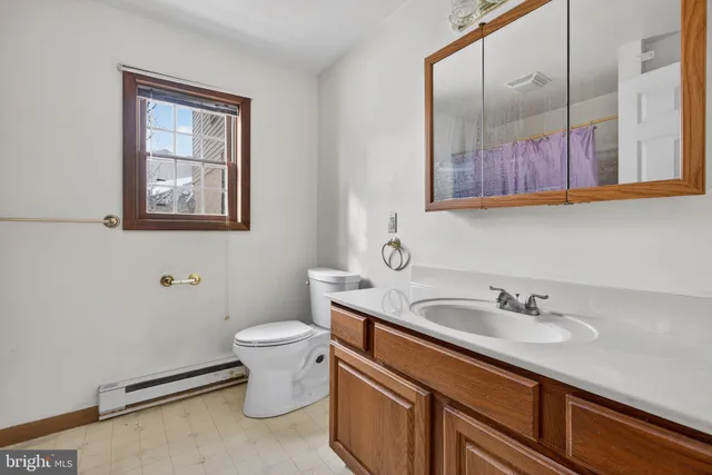 a bathroom with a sink toilet and a mirror