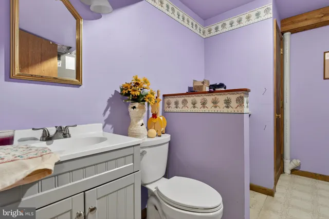 a bathroom with a granite countertop toilet sink and mirror