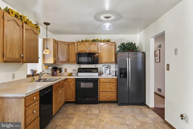 a kitchen with stainless steel appliances granite countertop a refrigerator stove and sink