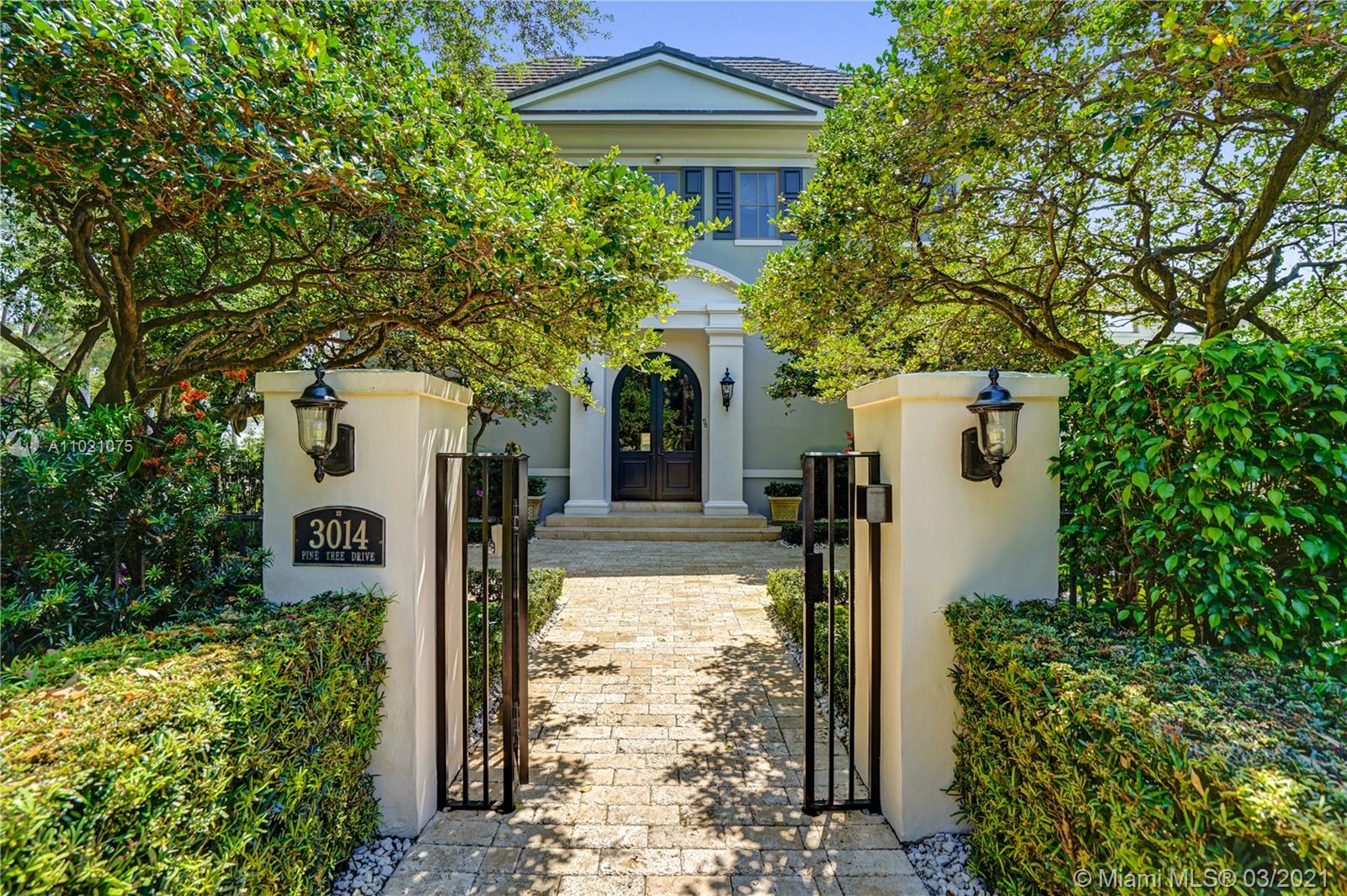 3014 Pine Tree Drive Miami Beach, FL 33140 - Photo 2 of 43 a front view of a house with trees