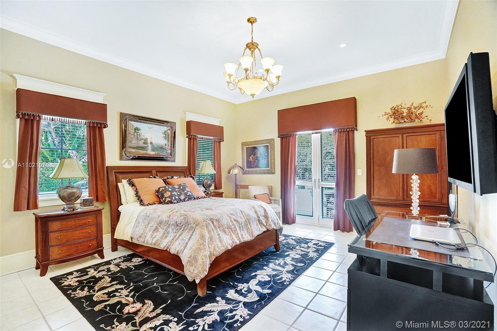 3014 Pine Tree Drive Miami Beach, FL 33140 - Photo 21 of 43 a bedroom with a bed and a chandelier