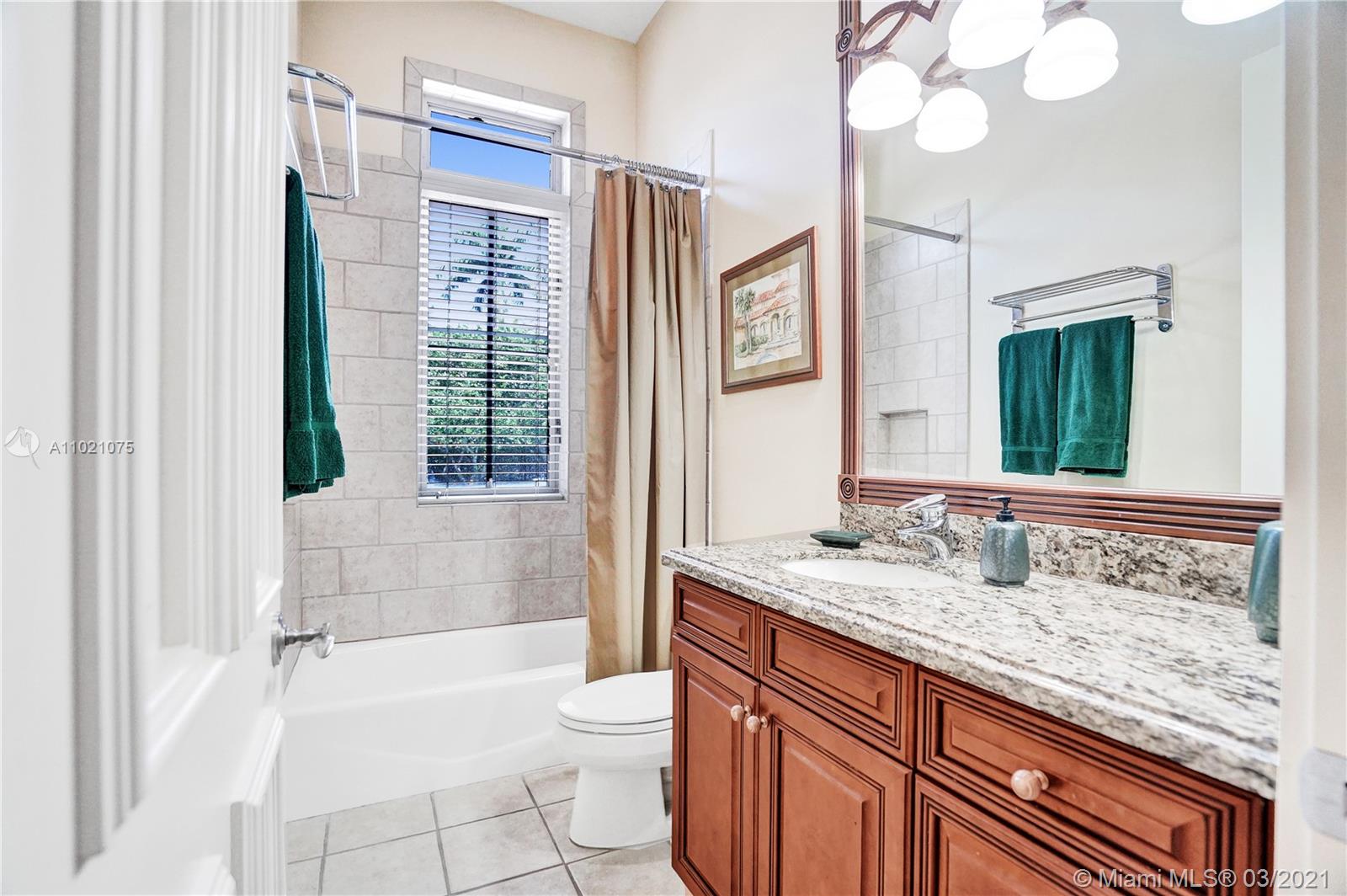 3014 Pine Tree Drive Miami Beach, FL 33140 - Photo 22 of 43 a bathroom with a granite countertop sink toilet mirror and bathtub