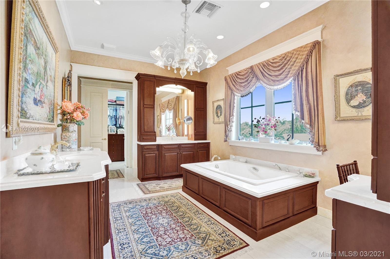 3014 Pine Tree Drive Miami Beach, FL 33140 - Photo 30 of 43 a spacious bathroom with a double vanity sink and a mirror