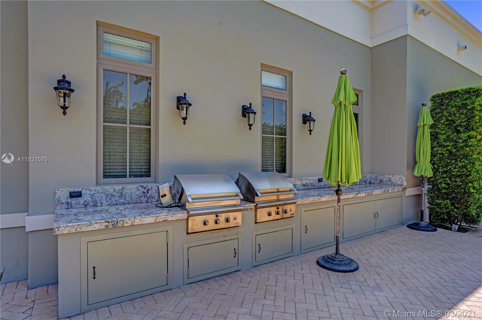 3014 Pine Tree Drive Miami Beach, FL 33140 - Photo 39 of 43 a kitchen with stainless steel appliances granite countertop a sink and a counter