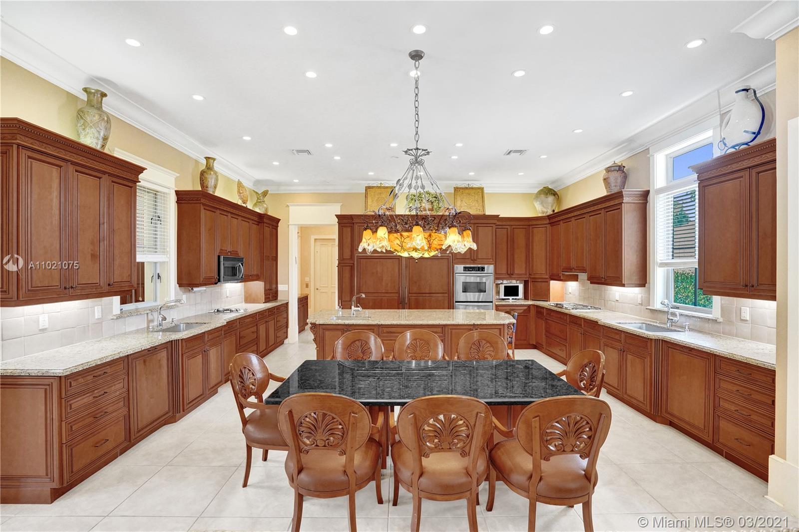 3014 Pine Tree Drive Miami Beach, FL 33140 - Photo 10 of 43 a large kitchen with a table and chairs in it