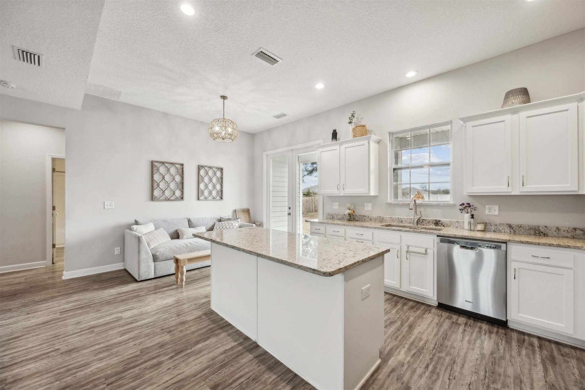 96718 Blackrock Road Yulee, FL 32097 - Photo 3 of 54 a kitchen with center island wooden floor and white cabinets