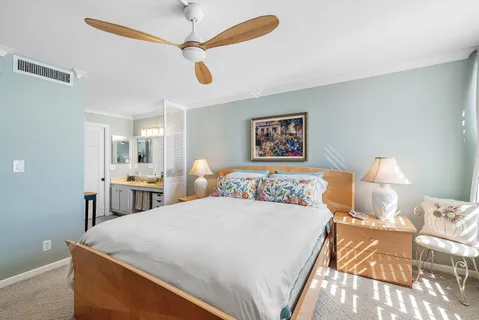 a bedroom with a large bed and a chandelier