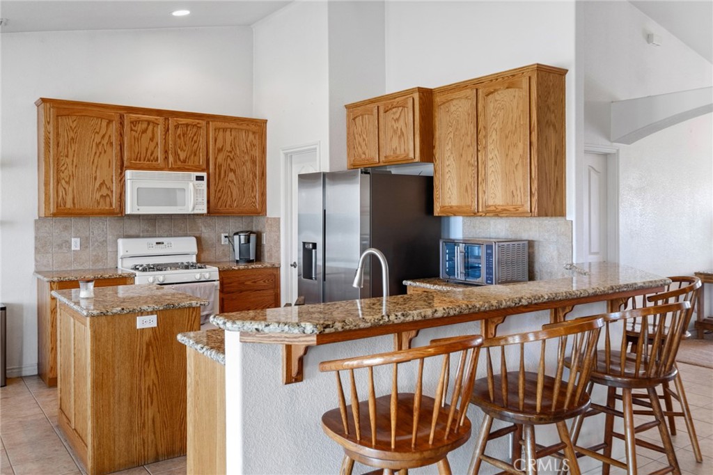 11025 El Esteban Road Phelan, CA 92371 - Photo 19 of 54 a kitchen with stainless steel appliances granite countertop a sink dishwasher a refrigerator and a stove with wooden floor