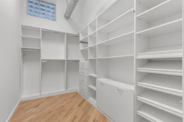 a view of walk in closet with empty racks