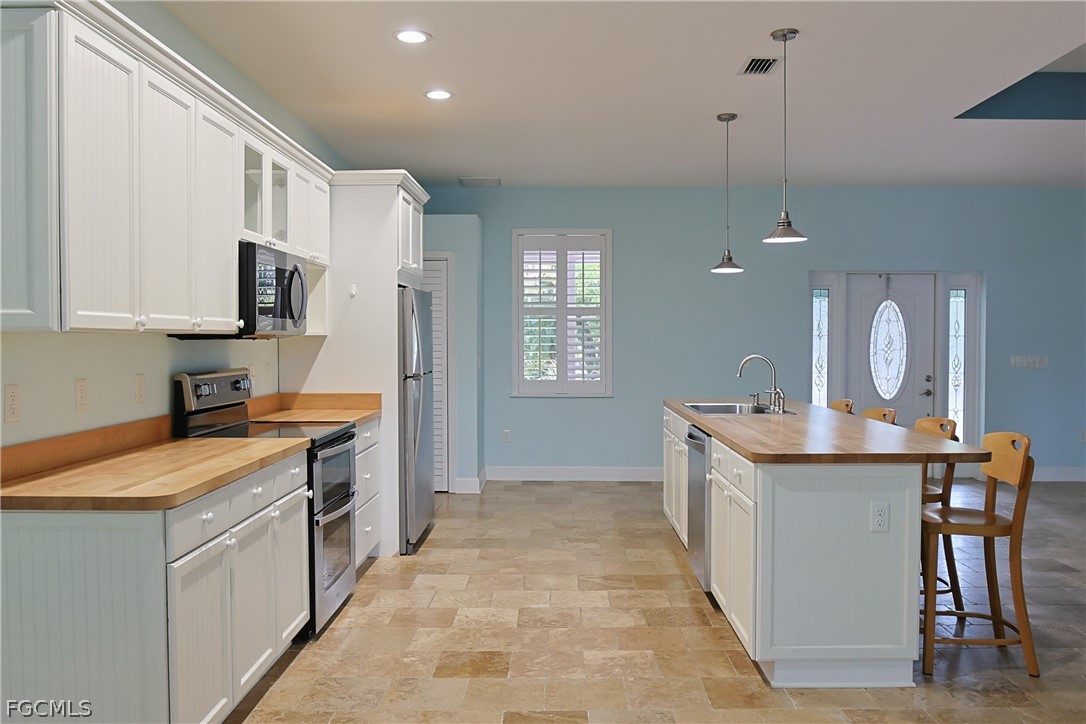 21531 Pearl Street Alva, FL 33920 - Photo 13 of 41 a kitchen with stainless steel appliances granite countertop a stove a sink a refrigerator and a wooden cabinets