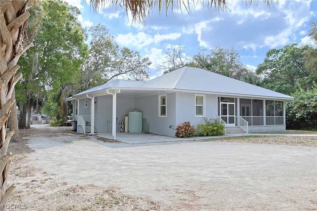 21531 Pearl Street Alva, FL 33920 - Photo 4 of 41 a front view of a house with a garden and porch