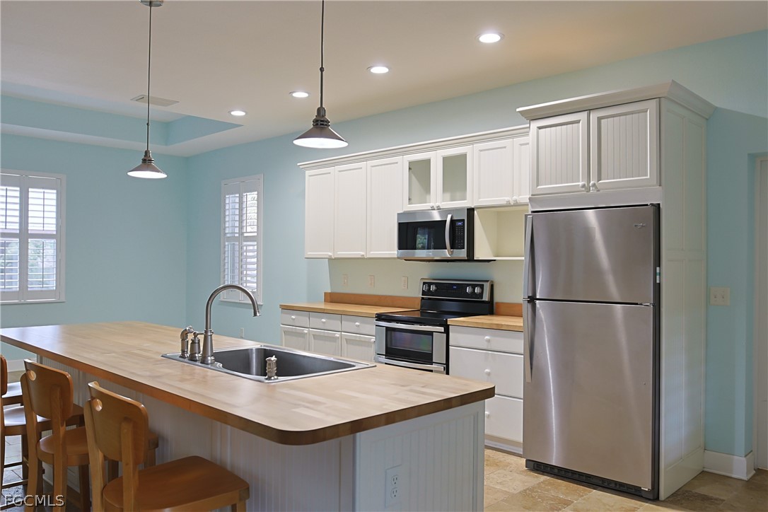 21531 Pearl Street Alva, FL 33920 - Photo 10 of 41 a kitchen with stainless steel appliances granite countertop a sink a stove a refrigerator and island with wooden floor