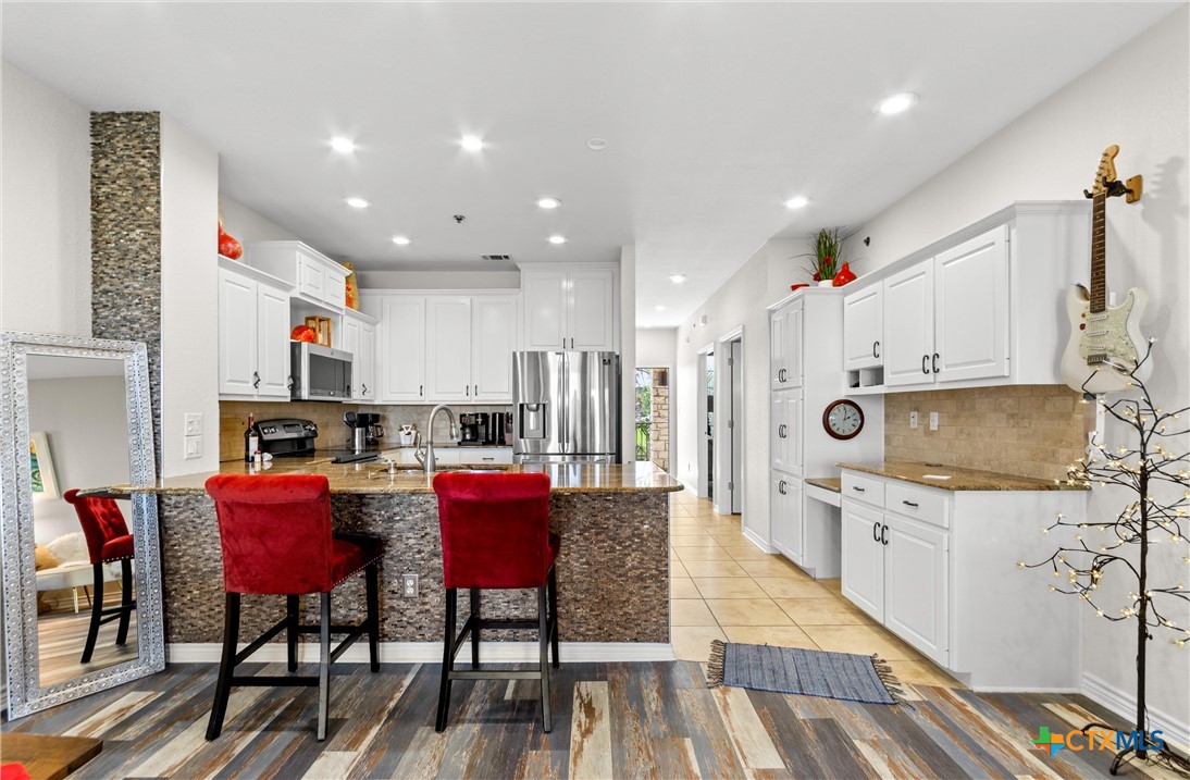 130 Sobrante Road, Unit 209 Belton, TX 76513 - Photo 9 of 36 a kitchen with stainless steel appliances kitchen island granite countertop a dining table chairs sink and white cabinets