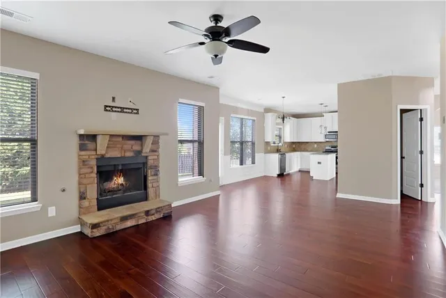 a view of empty room with wooden floor and a fireplace