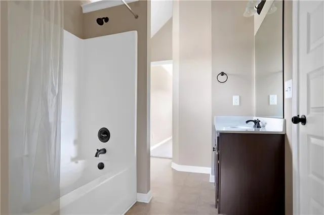 a bathroom with a tub sink and mirror