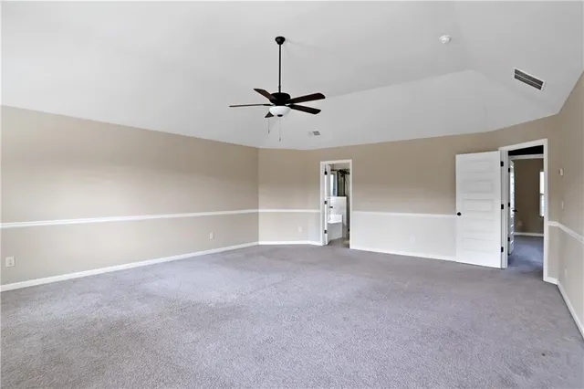 an empty room with a ceiling fan and a window