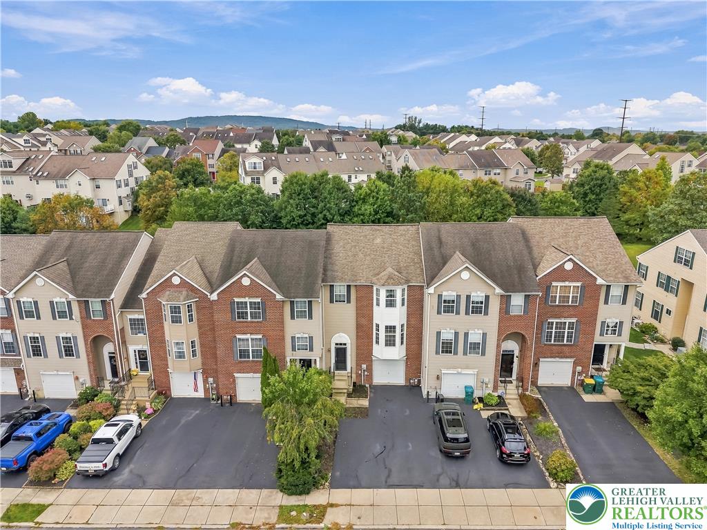5607 Spring Ridge Drive West Macungie, PA 18062 - Photo 2 of 26 A paved driveway and private garage access lead to each modern townhouse facade.