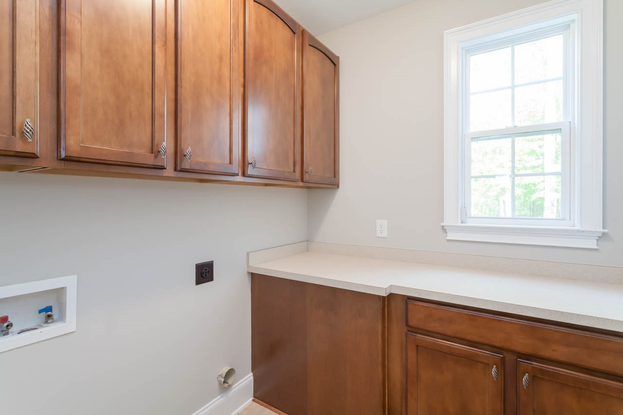 8915 Scotch Castle Drive Raleigh, NC 27612 - Photo 23 of 25 The laundry room is located on the 1st floor and features abundant storage and counter space. You will love all the cabinets! Laundry Room