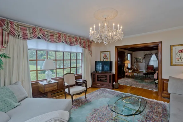 a living room with furniture chandelier and a fireplace