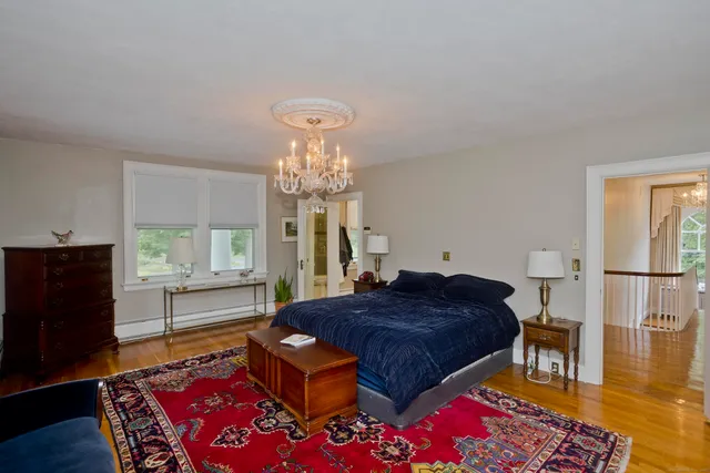 a spacious bedroom with a bed and wooden floor