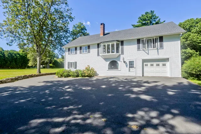 a front view of a house with a yard and a garage