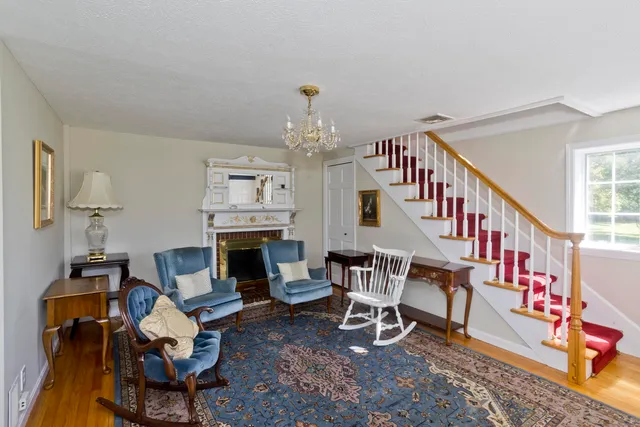 a living room with furniture a fireplace and a chandelier