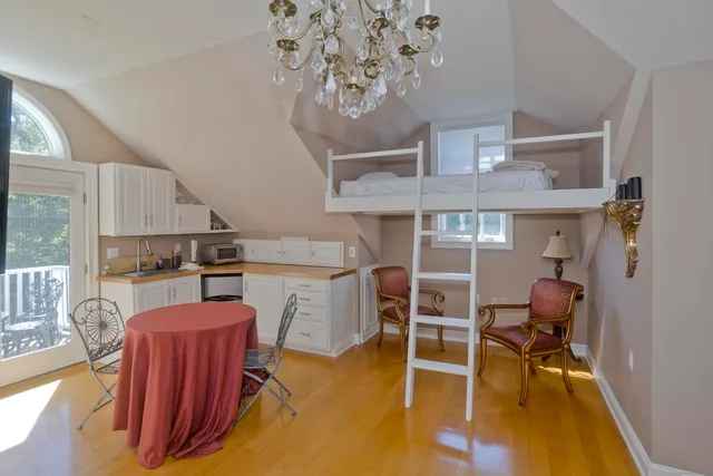 a living room with furniture a table and kitchen view