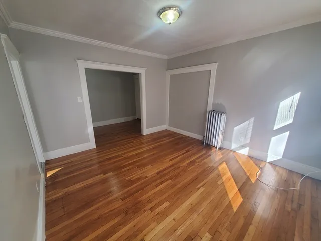 a view of empty room with wooden floor