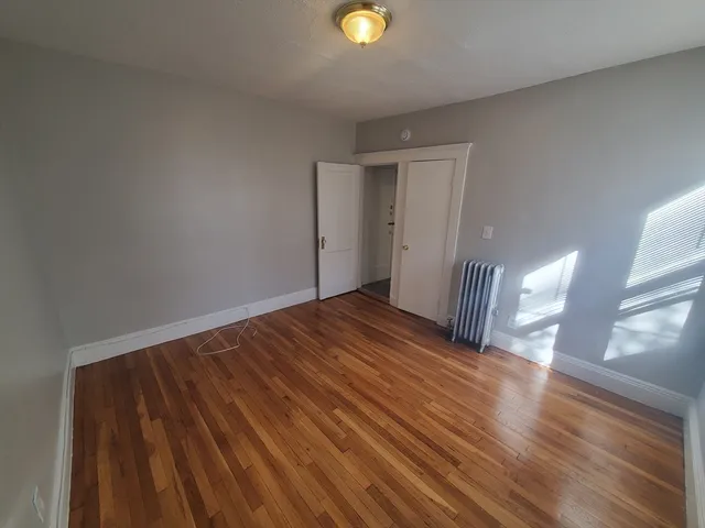 a view of a room with wooden floor and window
