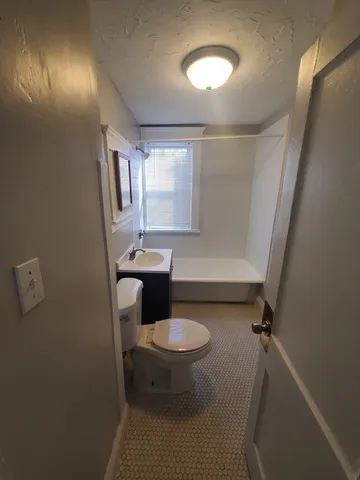 a bathroom with a sink toilet and mirror