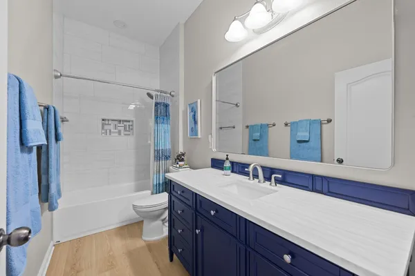 a bathroom with a double vanity sink toilet mirror and shower