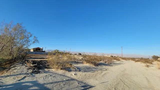 a view of a dry yard with mountains in the background
