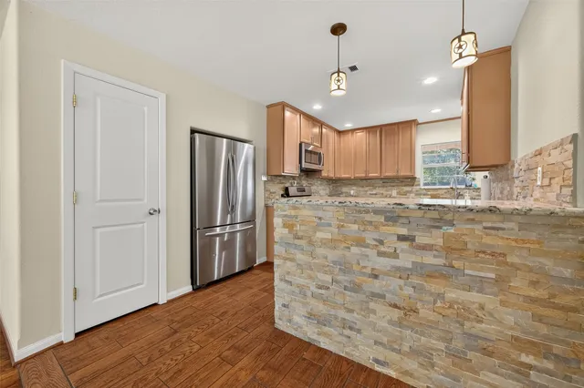 a kitchen with stainless steel appliances granite countertop a stove microwave and refrigerator