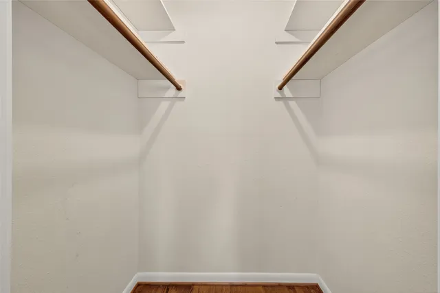 a bedroom with a bed ceiling fan and wooden floor