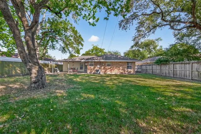 a view of a yard in front of a house with large tree