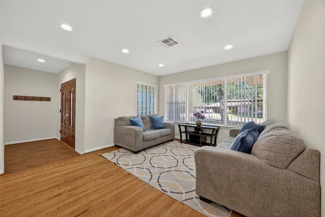 a living room with furniture and a wooden floor